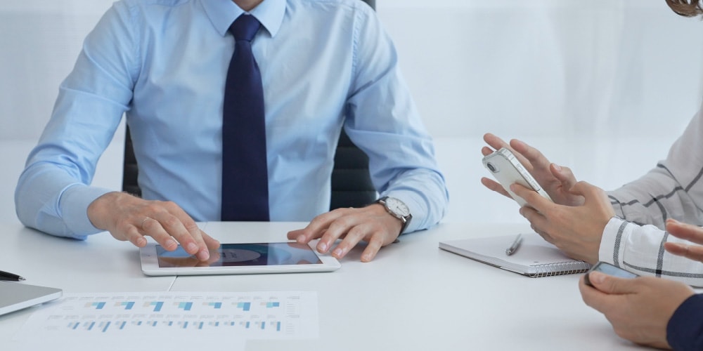 タブレットや資料を使って弁護士が依頼者と打ち合わせをする様子